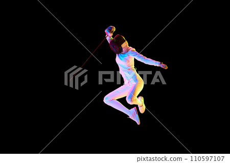 Self-defense skills. Although sportive, fencing skills can represent the broader theme of self-defense. Female athlete in motion, training over black background in neon. 110597107