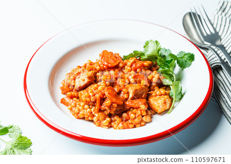 Ptitim with chicken, vegetables and cilantro, white background. Traditional Israeli food. 110597671