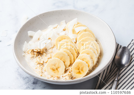 Overnight oatmeal with banana and coconut chips. Overnight oatmeal with banana and coconut chips. 110597686