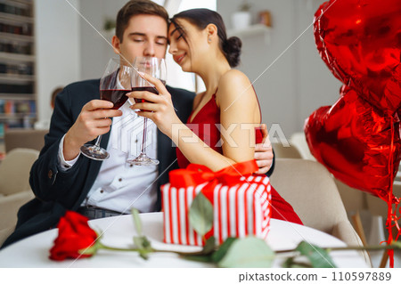 Young couple having romantic dinner and toasting with glass of red wine. Relationship, love concept. Young couple having romantic dinner and toasting with glass of red wine. Relationship, love concept. 110597889