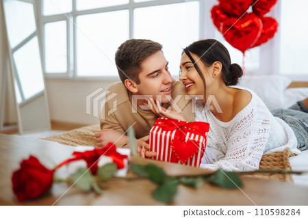Valentine's Day concept. Lovers give each other gifts. Couple at home celebrating Valentine's Day. 110598284