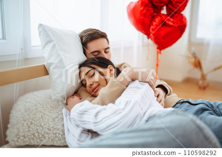 Valentine's Day concept. Lovers give each other gifts. Couple at home celebrating Valentine's Day. Valentine's Day concept. Lovers give each other gifts. Couple at home celebrating Valentine's Day. 110598292