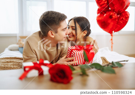 Valentine's Day concept. Lovers give each other gifts. Couple at home celebrating Valentine's Day. 110598324
