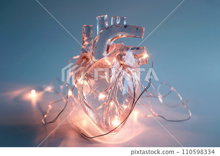 Human heart made of glass or ice with light garland. Anatomically correct heart on blue background. Glowing frozen heart, love and romantic concept Human heart made of glass or ice with light garland. Anatomically correct heart on blue background. Glowing frozen heart, love and romantic concept 110598334