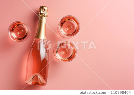 Champagne bottle with glasses on pastel background. Party background with sparkling wine, bubbling rose champagne, celebration concept. Girls only party, bachelorette, hen night. Minimal composition Champagne bottle with glasses on pastel background. Party background with sparkling wine, bubbling rose champagne, celebration concept. Girls only party, bachelorette, hen night. Minimal composition 110598404