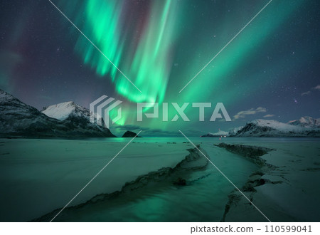 Northern Lights, snowy mountains, sandy beach, creek at night 110599041