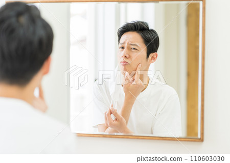 一名中年男子戴上口罩後檢查皮膚是否粗糙。 110603030