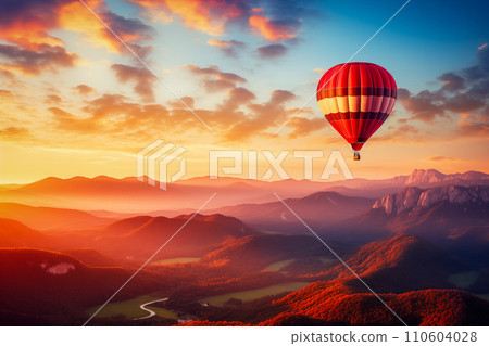 Colorful hot air balloon over desert mountains at sunset 110604028