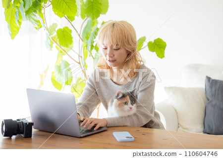 Woman and cat looking at computer 110604746