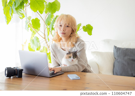 Woman and cat looking at computer 110604747