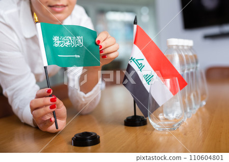 Unrecognizable girl sets midget flags of Iraq and Saudi Arabia before international negotiations Unrecognizable girl sets midget flags of Iraq and Saudi Arabia before international negotiations 110604801