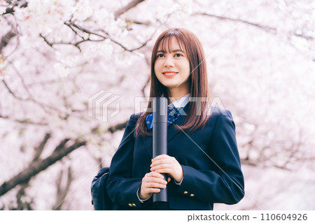 High school student (high school girl) looking up at the cherry blossoms and holding a diploma High school student (high school girl) looking up at the cherry blossoms and holding a diploma 110604926