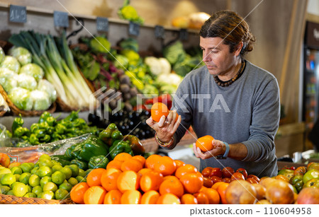 Adult man buyer chooses tangerines in shop 110604958