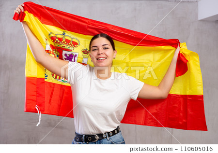 Smiling young woman holding Spain flag 110605016