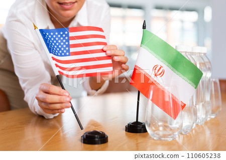 Preparing for business presentation - secretary places flags of Iran and USA on negotiating table Preparing for business presentation - secretary places flags of Iran and USA on negotiating table 110605238