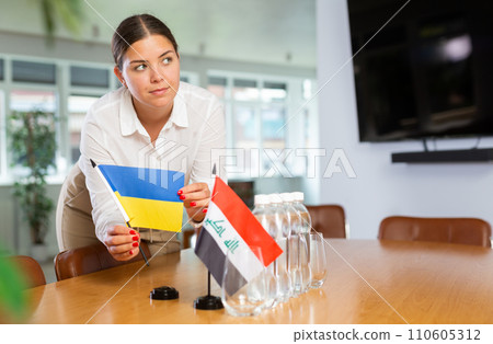 Young lady sets miniatures flags of Iraq and Ukraine for international negotiations Young lady sets miniatures flags of Iraq and Ukraine for international negotiations 110605312