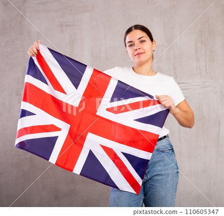 Smiling young woman holding United Kingdom flag 110605347