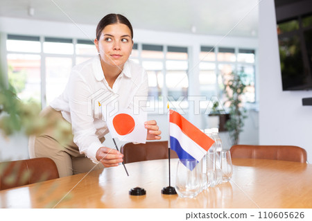 Businesswoman arranging the flags of Japan and Netherlands for presentation and negotiations Businesswoman arranging the flags of Japan and Netherlands for presentation and negotiations 110605626