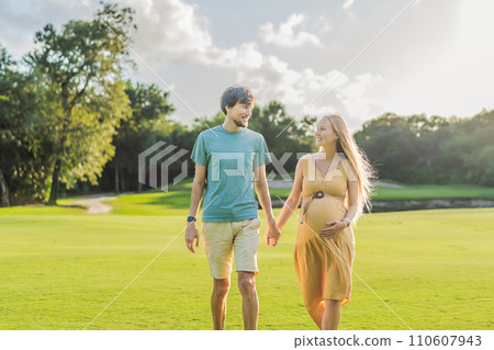 A blissful moment as a pregnant woman and her husband spend quality time together outdoors, savoring each other's company and enjoying the serenity of nature A blissful moment as a pregnant woman and her husband spend quality time together outdoors, savoring each other's company and enjoying the serenity of nature 110607943