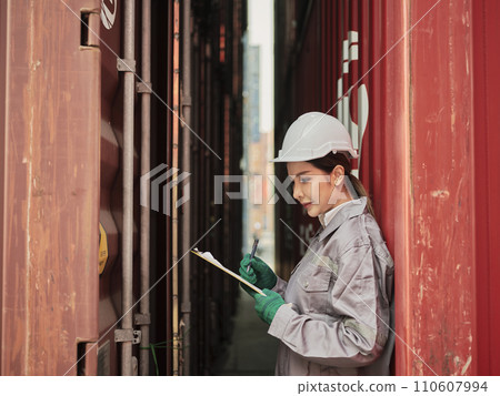 Asian woman worker holding clipboard and inspection container . Asian woman worker holding clipboard and inspection container . 110607994