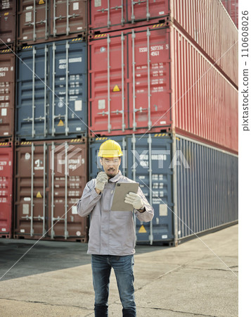 Asian worker using walkie talkie communicate with container team 110608026