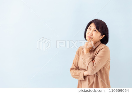 Worried senior woman blue background Worried senior woman blue background 110609064