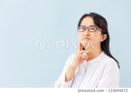 Worried senior woman blue background 110609072