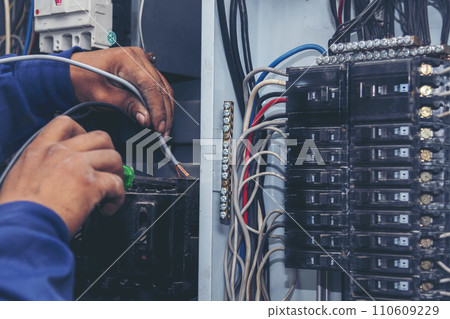 Inspector men hands working switchboard machinery maintenance service. Electrical mechanic technician check wire electric cabinet.  Electrician circuit repair voltage operation. Men hands fix breaker 110609229