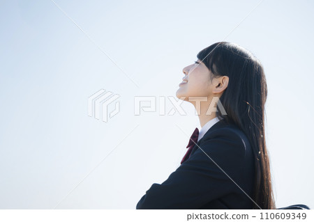 A high school girl standing by the river under the blue sky. An image full of hope looking up at her goals, future, and hopes. A high school girl standing by the river under the blue sky. An image full of hope looking up at her goals, future, and hopes. 110609349