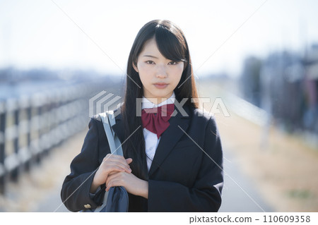A high school girl looking at the camera with a serious expression outdoors, career path, etc. A high school girl looking at the camera with a serious expression outdoors, career path, etc. 110609358