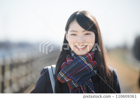 戴著圍巾的高中女孩在戶外秋冬季微笑著看著鏡頭 110609361