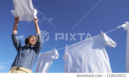 藍天下，一名中年男子正在晾襯衫 110610052