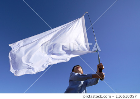 A boy waving a flag under the blue sky A boy waving a flag under the blue sky 110610057
