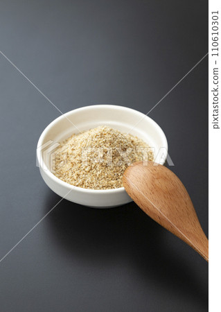 黑色背景碗中的磨碎芝麻和木勺 110610301