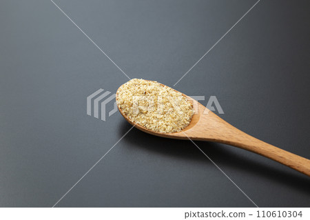 木匙上磨碎的芝麻,黑色背景 木匙上磨碎的芝麻,黑色背景 110610304