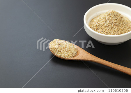 黑色背景碗中的磨碎芝麻和木勺 110610306