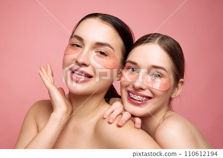 Hydrated harmony. Young girls embrace their makeup-free charm, coming together to care under-eye area with moisturized, hyaluronic patches Hydrated harmony. Young girls embrace their makeup-free charm, coming together to care under-eye area with moisturized, hyaluronic patches 110612194