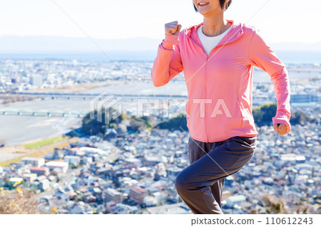 Middle-aged woman running outdoors 110612243