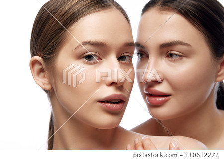Portrait of two young beautiful young Caucasian woman with clean fresh skin against white studio background. Portrait of two young beautiful young Caucasian woman with clean fresh skin against white studio background. 110612272