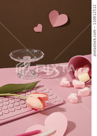 Adorable keyboard with a tulip flowers placed on, arranged with crayons, heart papers and a cup filled with marshmallows. Pink valentines or anniversary background Adorable keyboard with a tulip flowers placed on, arranged with crayons, heart papers and a cup filled with marshmallows. Pink valentines or anniversary background 110612512