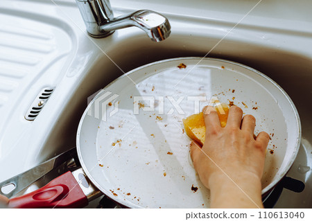 Washing dirty dishes in kitchen sink after dinner Washing dirty dishes in kitchen sink after dinner 110613040