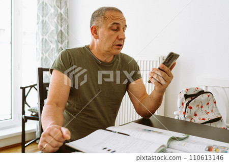 middle-aged man writes notes in notebook middle-aged man writes notes in notebook 110613146