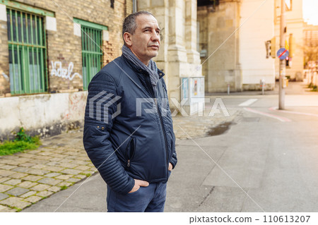 Lonely handsome middle-aged man on blurred background of city street Lonely handsome middle-aged man on blurred background of city street 110613207