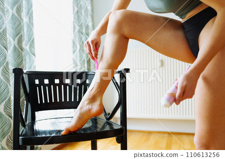 young woman shaves legs with special hair removal cream at home young woman shaves legs with special hair removal cream at home 110613256