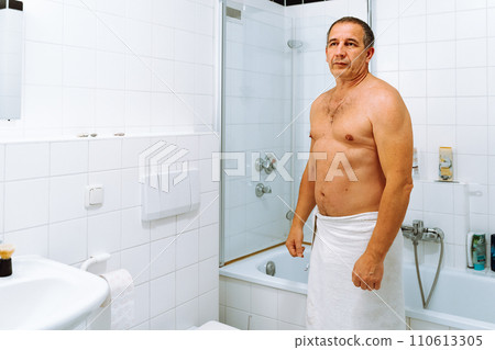 Portrait man after shower in bathroom with white tiled floor and walls Portrait man after shower in bathroom with white tiled floor and walls 110613305