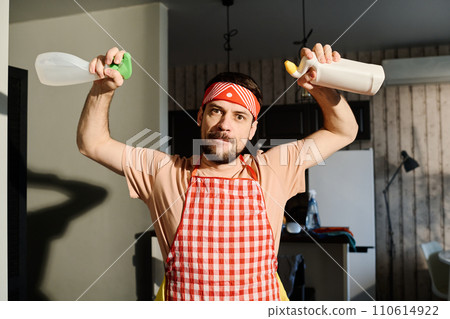 Young man with two bottles of detergents 110614922