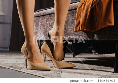 Close-up view of a woman putting on a shoe 110615701