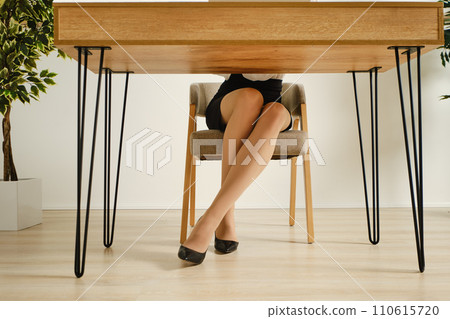 Female legs in pantyhose under the office table Female legs in pantyhose under the office table 110615720