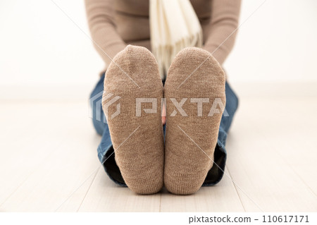 Feet of a middle-aged woman wearing thick winter socks 110617171
