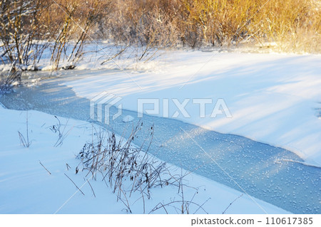Winter specific. Frozen river. Winter wonderland. Snow-blanketed countryside, the calm and serenity of a winter day in the heart of the rural landscape. 110617385